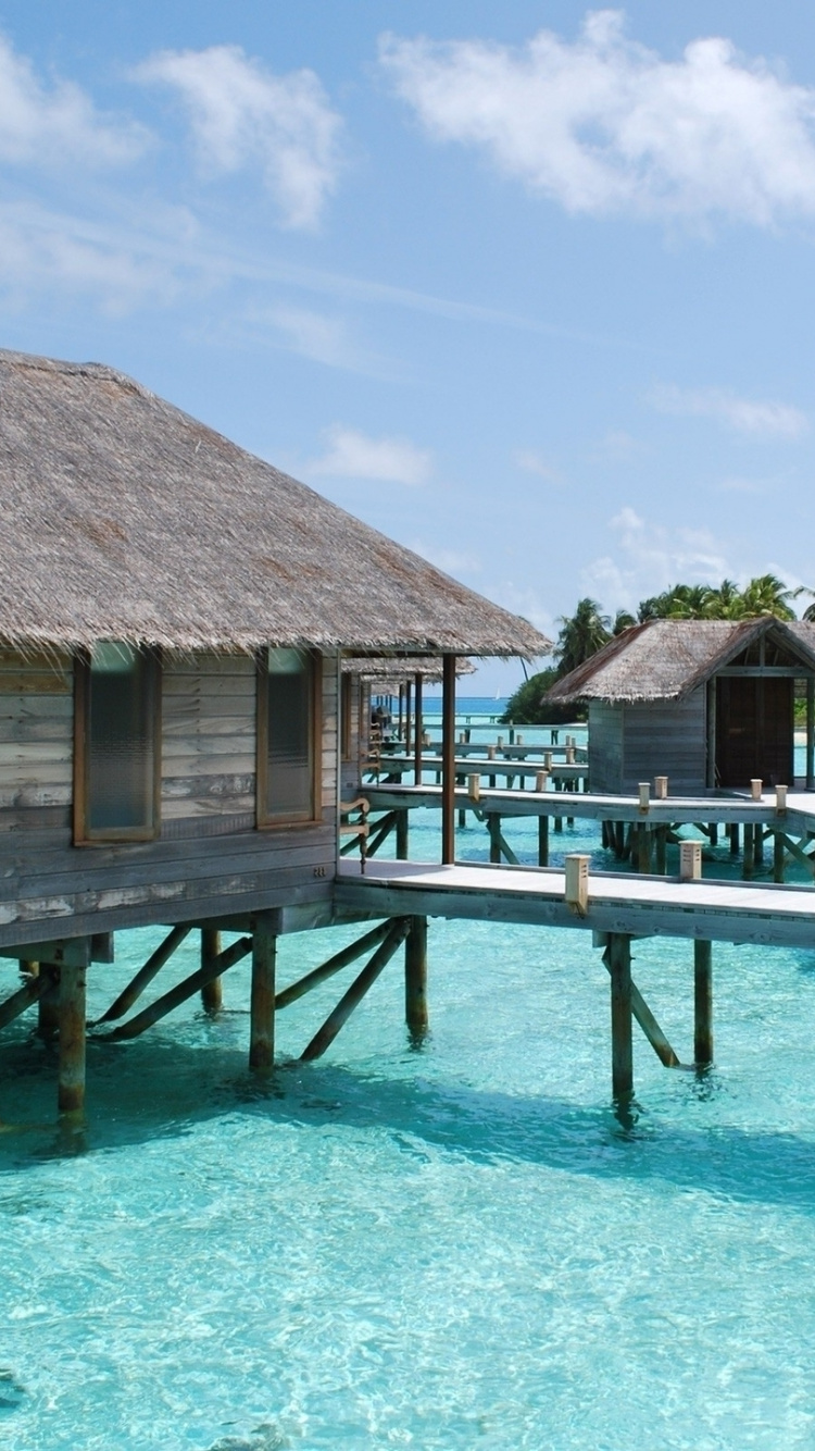 Brown Wooden House on Blue Sea Under Blue Sky During Daytime. Wallpaper in 750x1334 Resolution