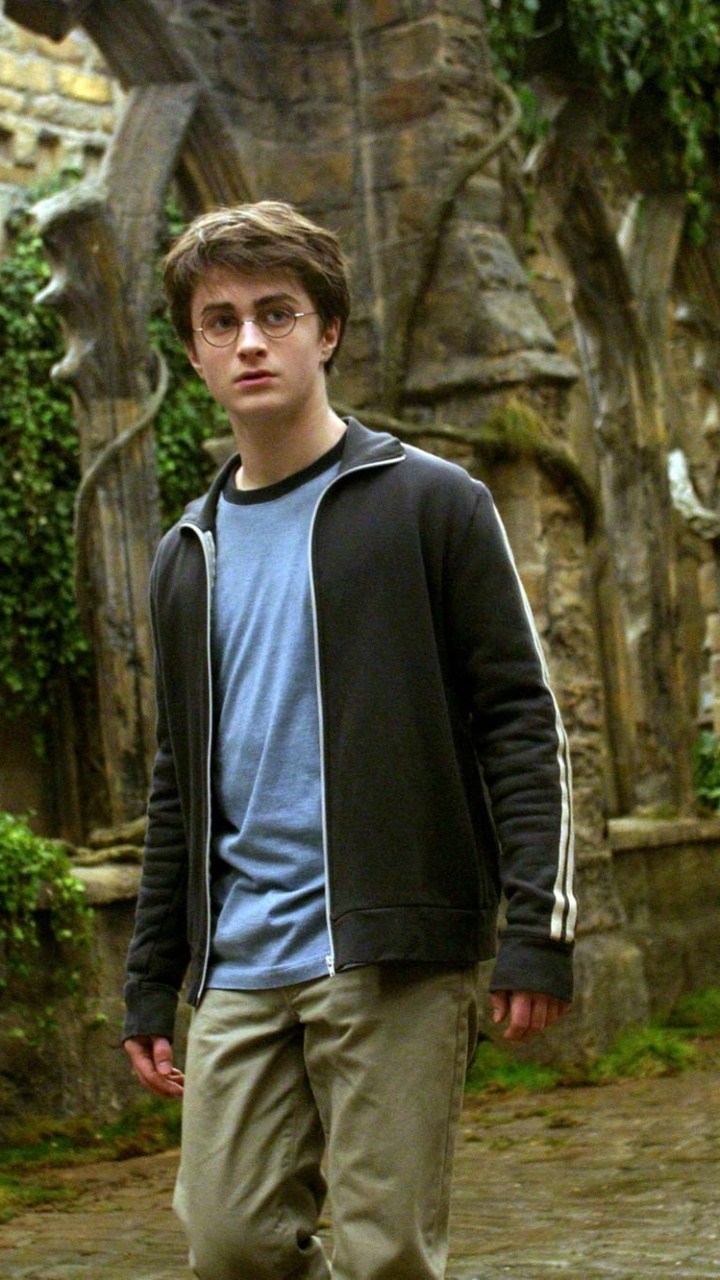 Mann in Schwarzer Jacke Und Grauer Hose, Der Tagsüber in Der Nähe Einer Braunen Betonmauer Steht. Wallpaper in 720x1280 Resolution