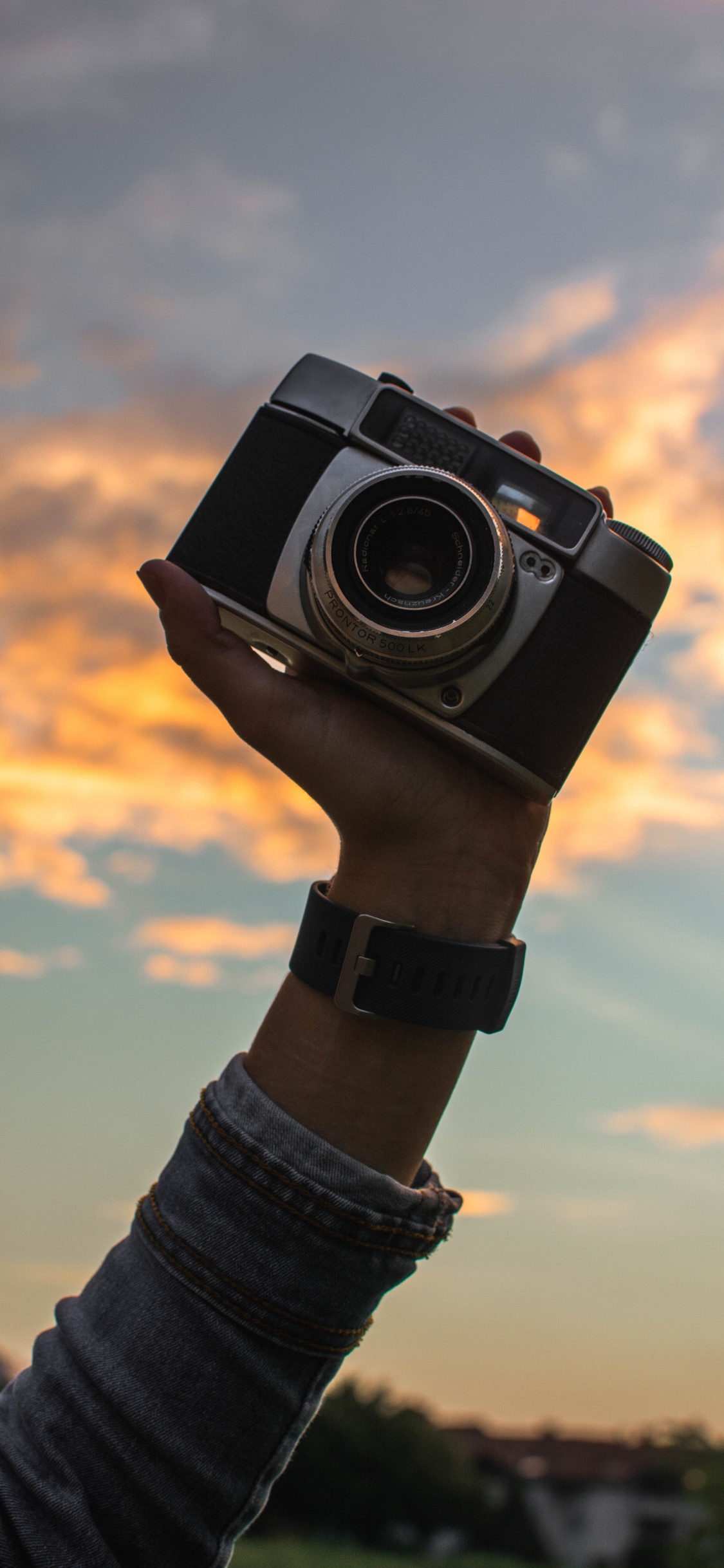 Person Holding Black and Silver Camera. Wallpaper in 1125x2436 Resolution