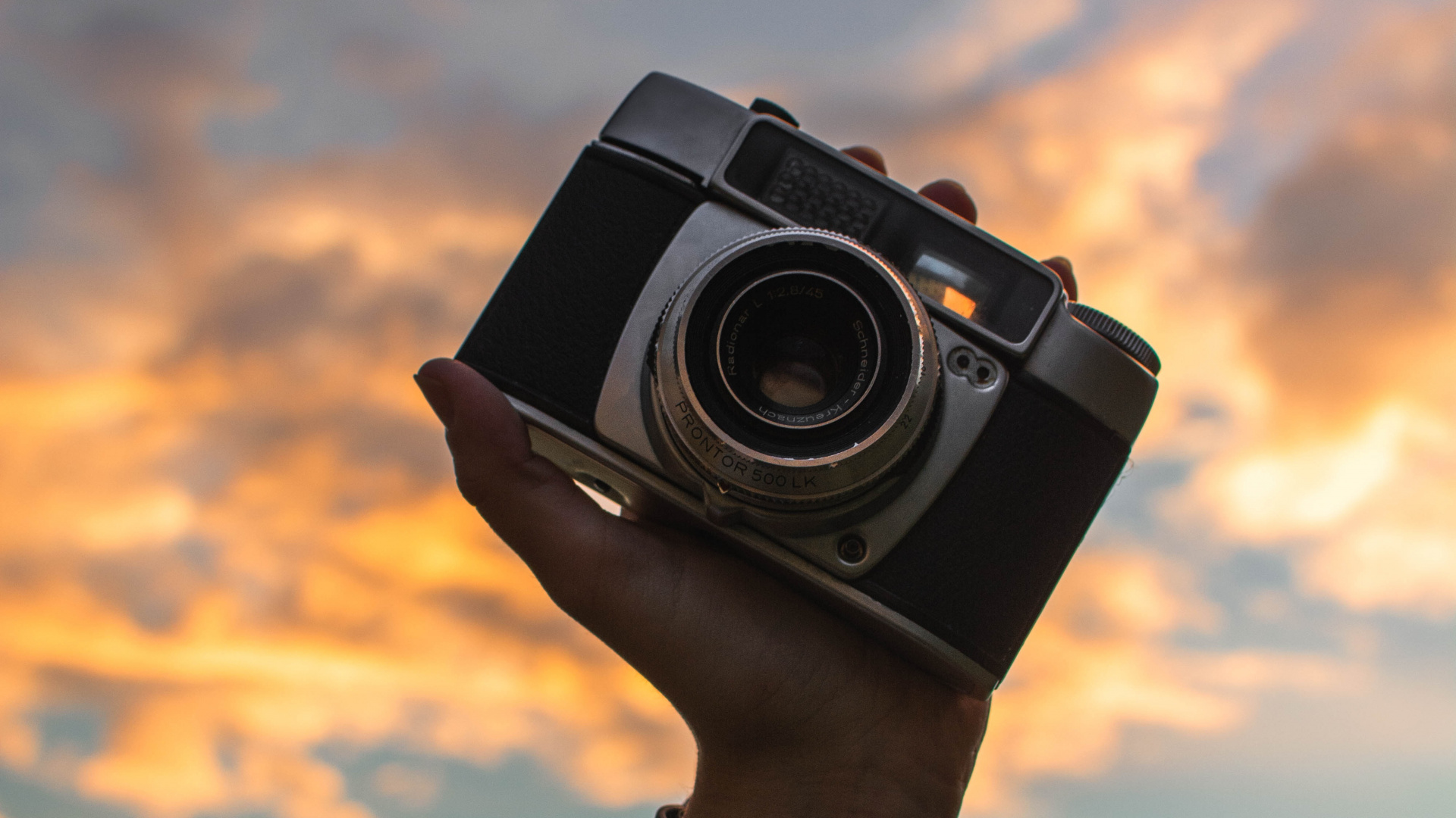 Person Holding Black and Silver Camera. Wallpaper in 1920x1080 Resolution
