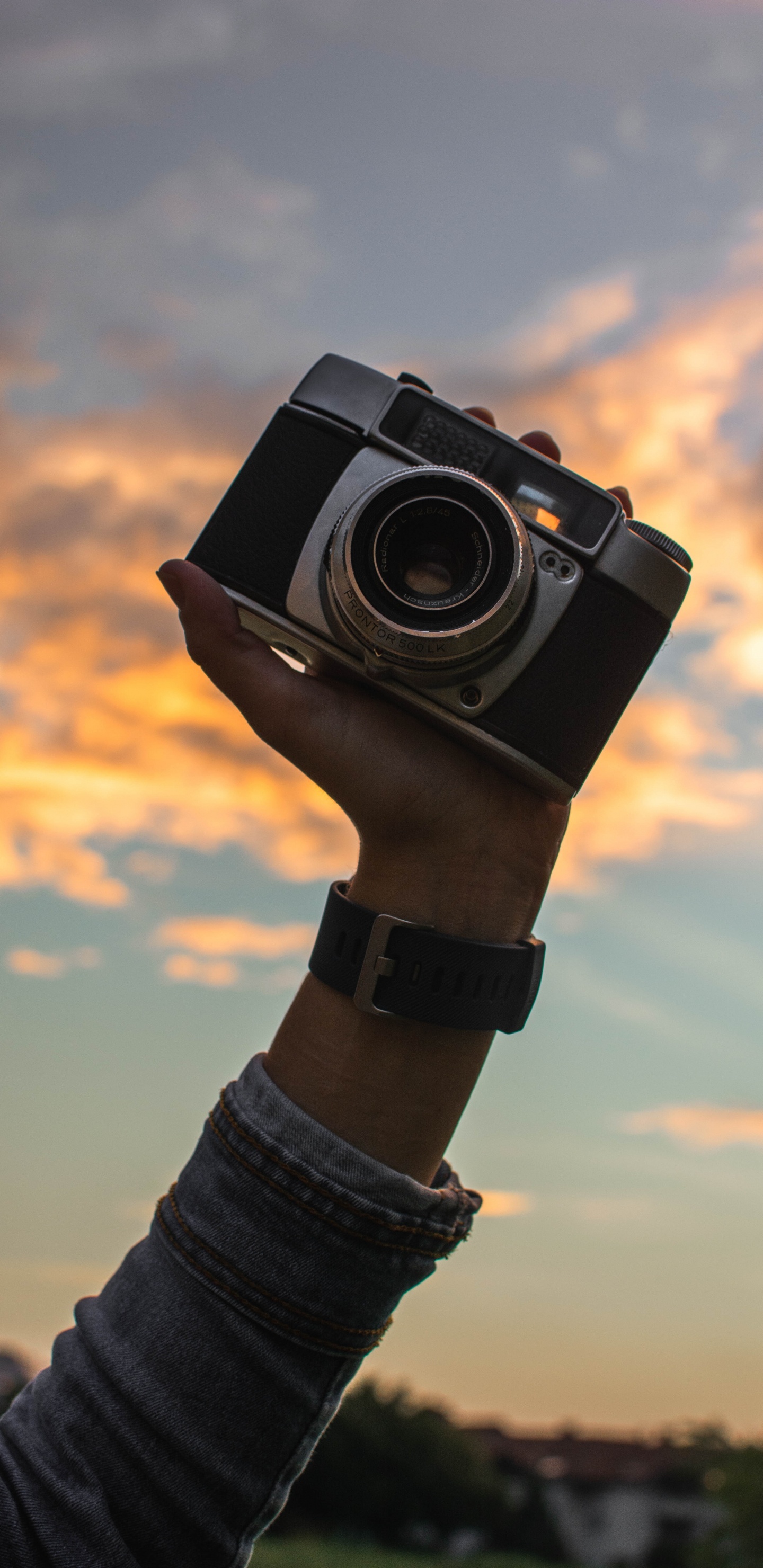 Persona Sosteniendo Una Cámara Negra y Plateada. Wallpaper in 1440x2960 Resolution