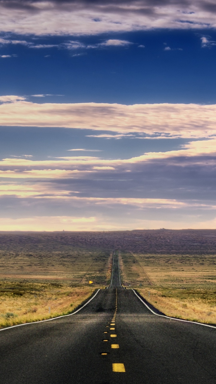 Black Asphalt Road Between Green Grass Field Under Blue and White Sunny Cloudy Sky During Daytime. Wallpaper in 720x1280 Resolution