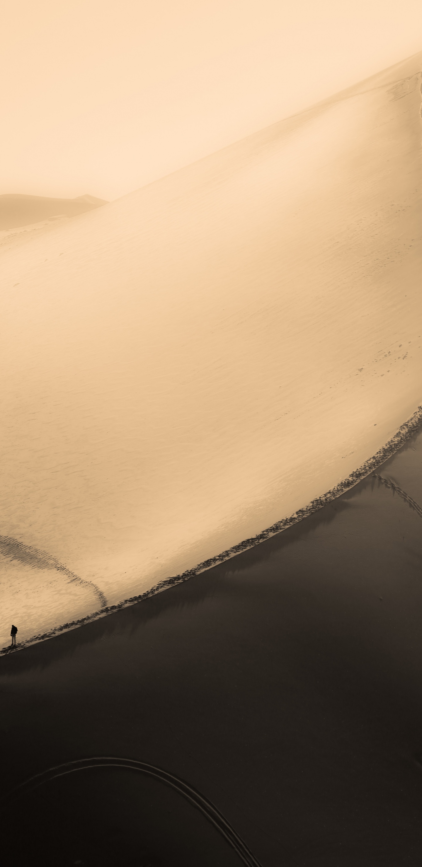 Person in Schwarzer Jacke, Die Auf Sand Geht. Wallpaper in 1440x2960 Resolution