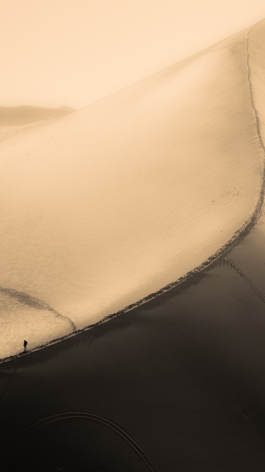 Person in Black Jacket Walking on Sand. Wallpaper in 1080x1920 Resolution