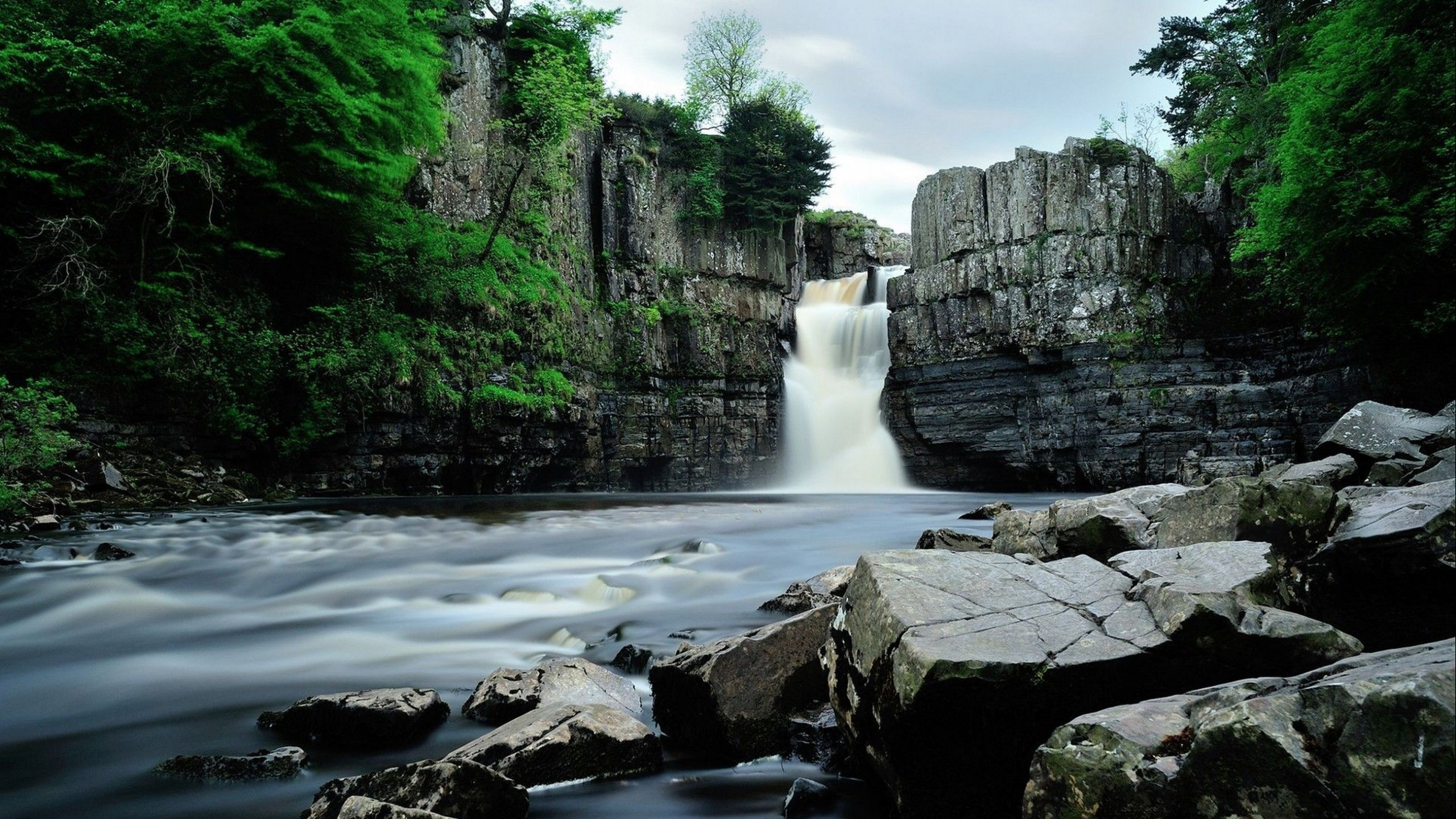 Waterfalls Between Gray Rocky Mountain Under Gray Sky During Daytime. Wallpaper in 2560x1440 Resolution