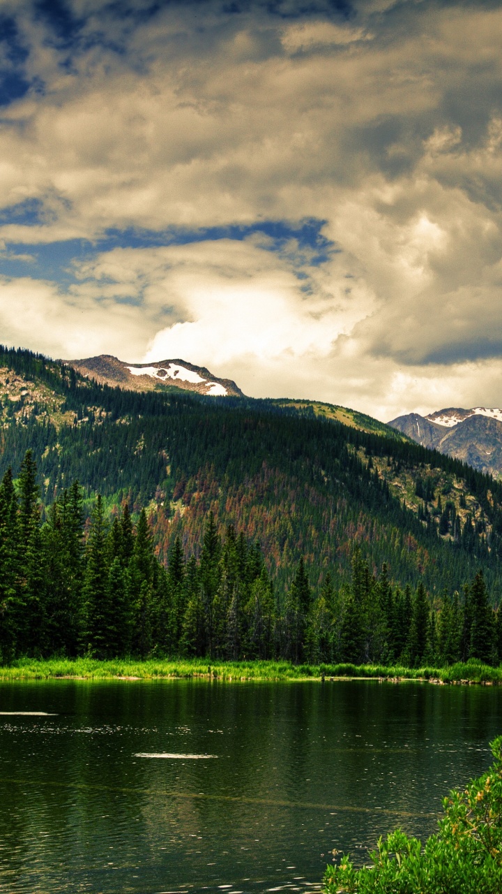 Lake Surrounded by Trees and Mountains Under Cloudy Sky During Daytime. Wallpaper in 720x1280 Resolution