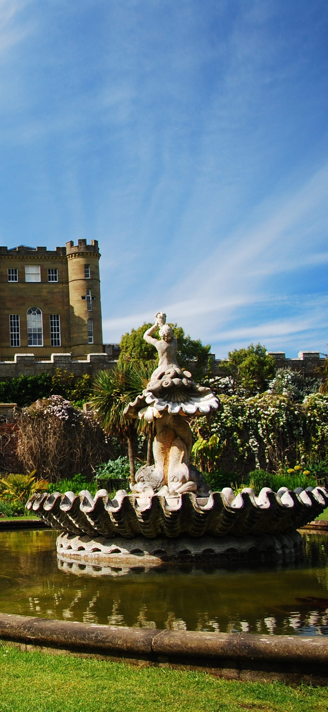 Braunes Betongebäude in Der Nähe Von Grünen Bäumen Unter Blauem Himmel Tagsüber. Wallpaper in 1125x2436 Resolution