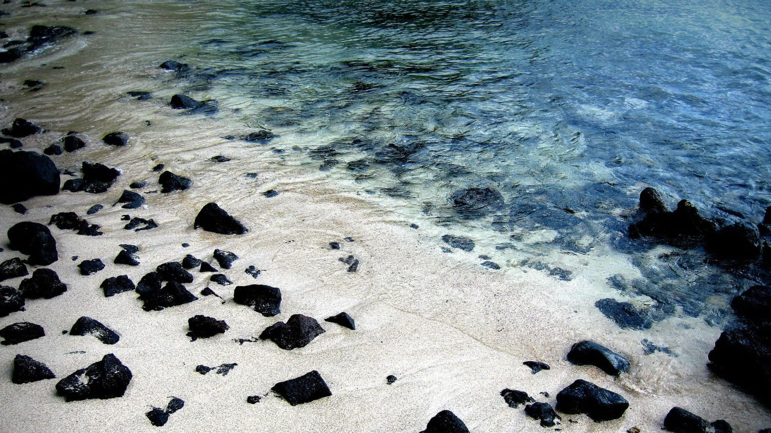 Piedras Negras en la Orilla Del Mar Durante el Día. Wallpaper in 2560x1440 Resolution