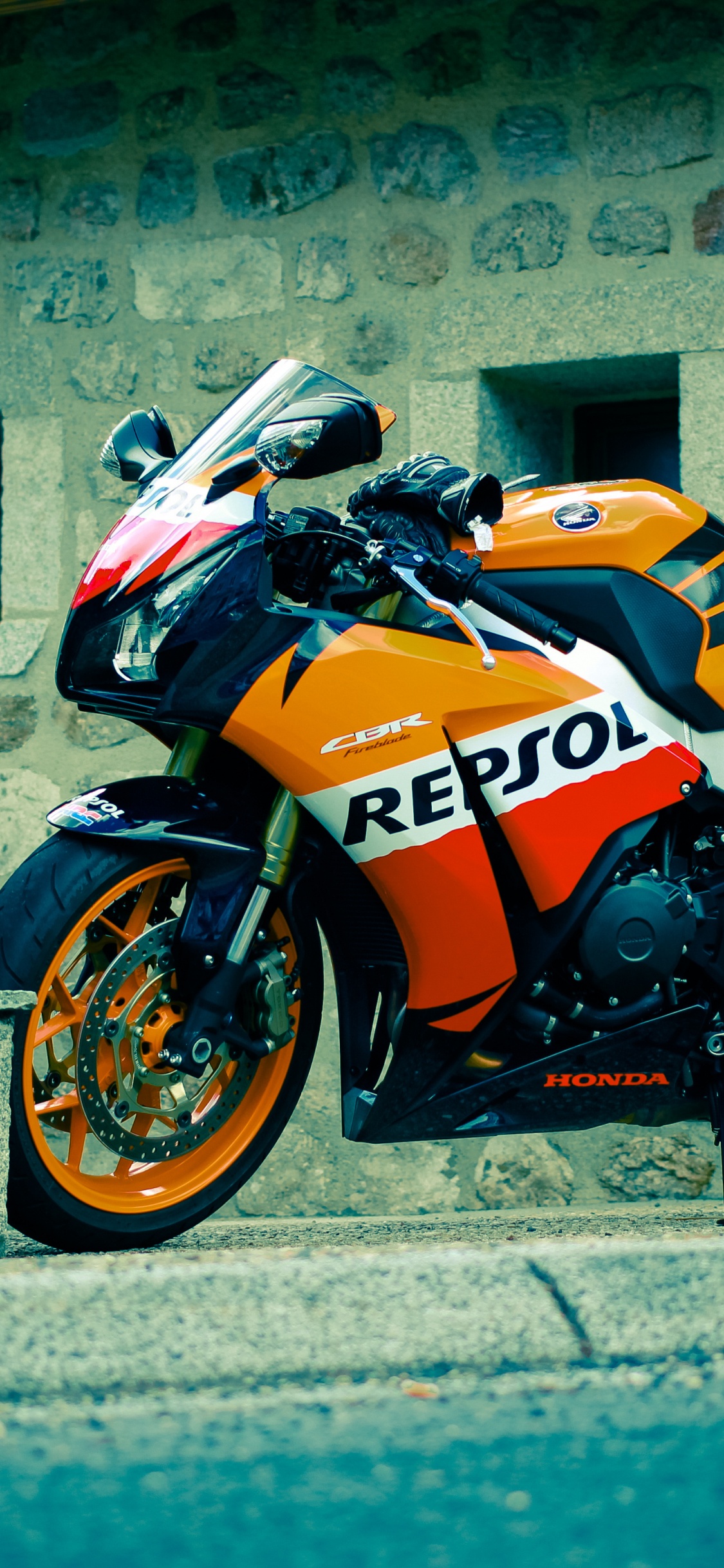 Orange and Black Sports Bike Parked Beside Gray Concrete Wall During Daytime. Wallpaper in 1125x2436 Resolution