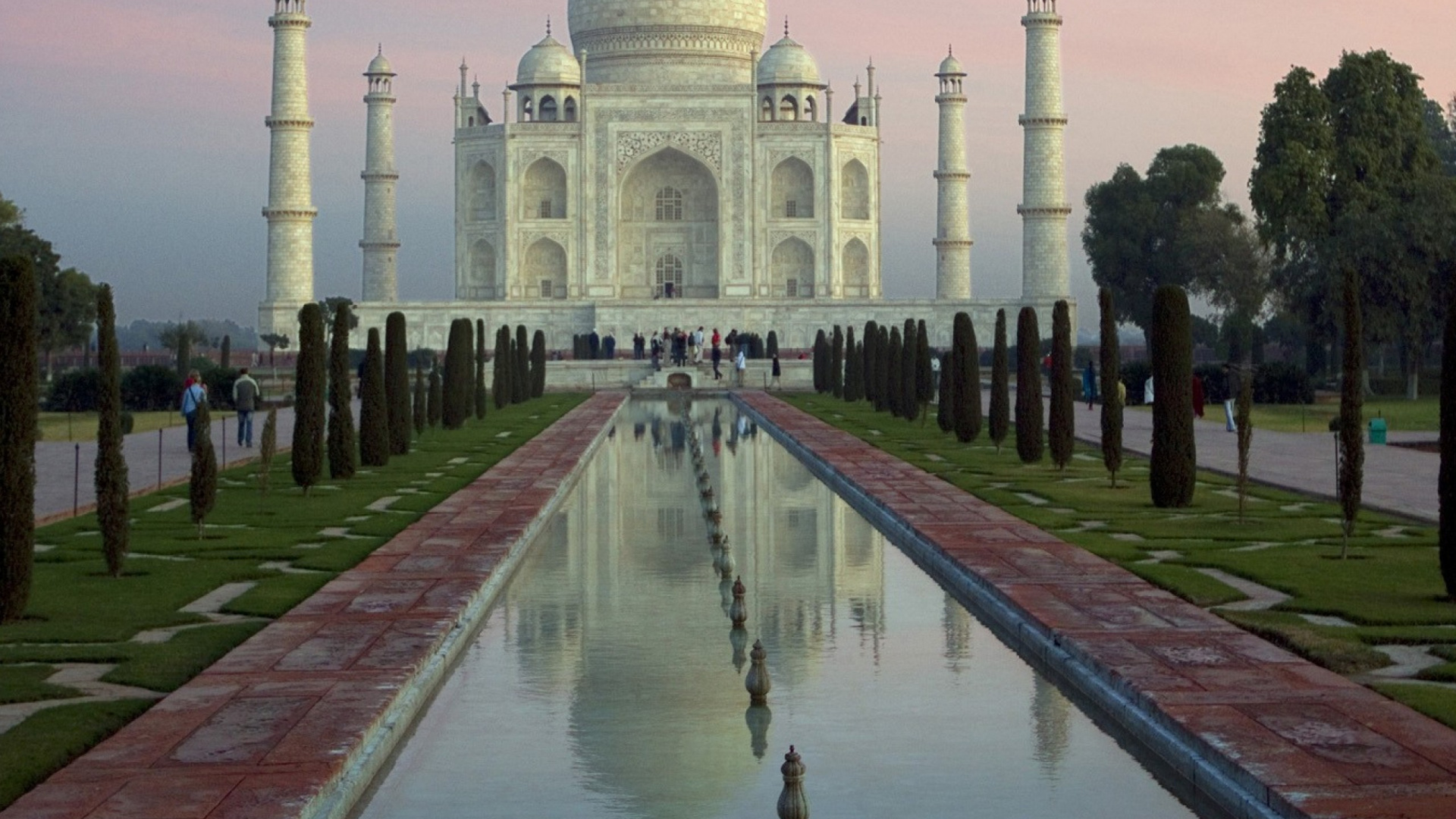 People Walking on Park Near White Concrete Building During Daytime. Wallpaper in 1920x1080 Resolution