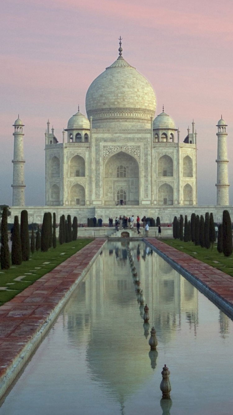 Leute, Die Tagsüber Auf Einem Park in Der Nähe Eines Weißen Betongebäudes Spazieren Gehen. Wallpaper in 750x1334 Resolution