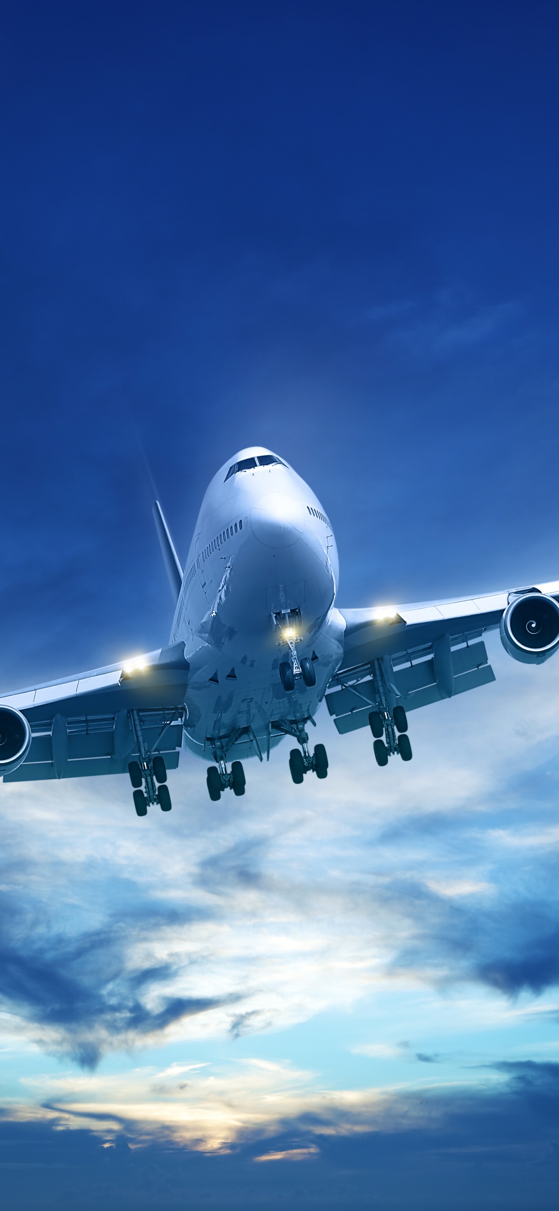 White and Blue Airplane Under Blue Sky During Daytime. Wallpaper in 1125x2436 Resolution