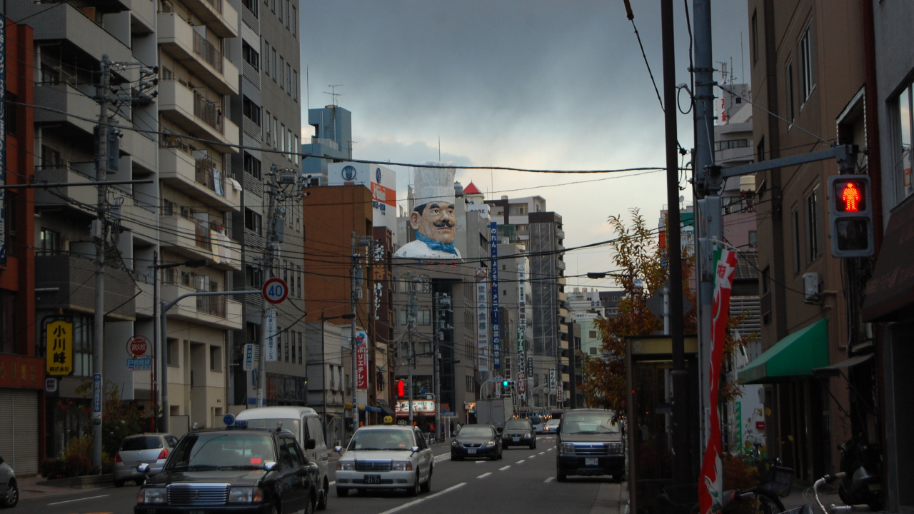 Cars on Road Between High Rise Buildings During Daytime. Wallpaper in 1280x720 Resolution