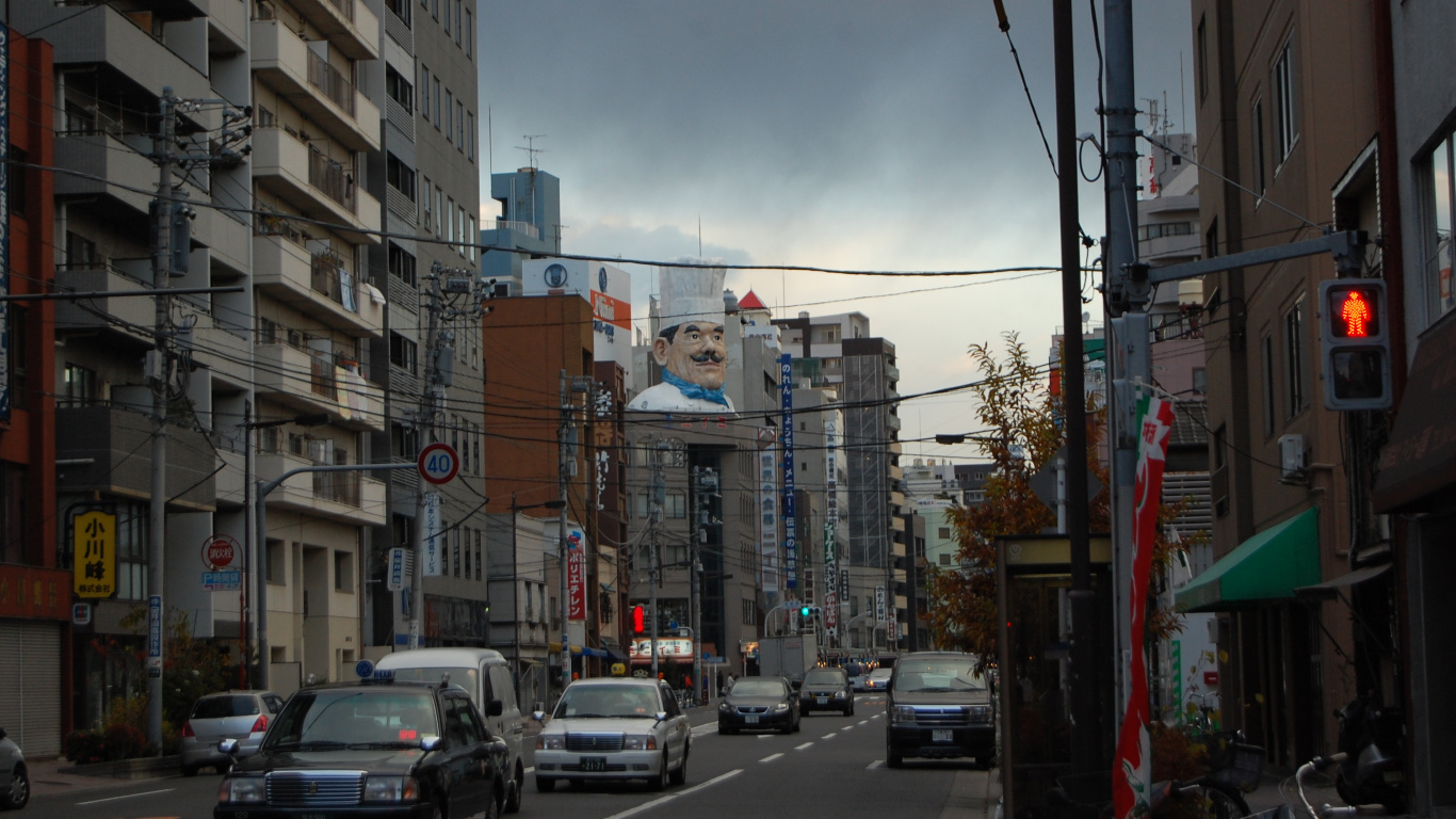 Cars on Road Between High Rise Buildings During Daytime. Wallpaper in 1366x768 Resolution