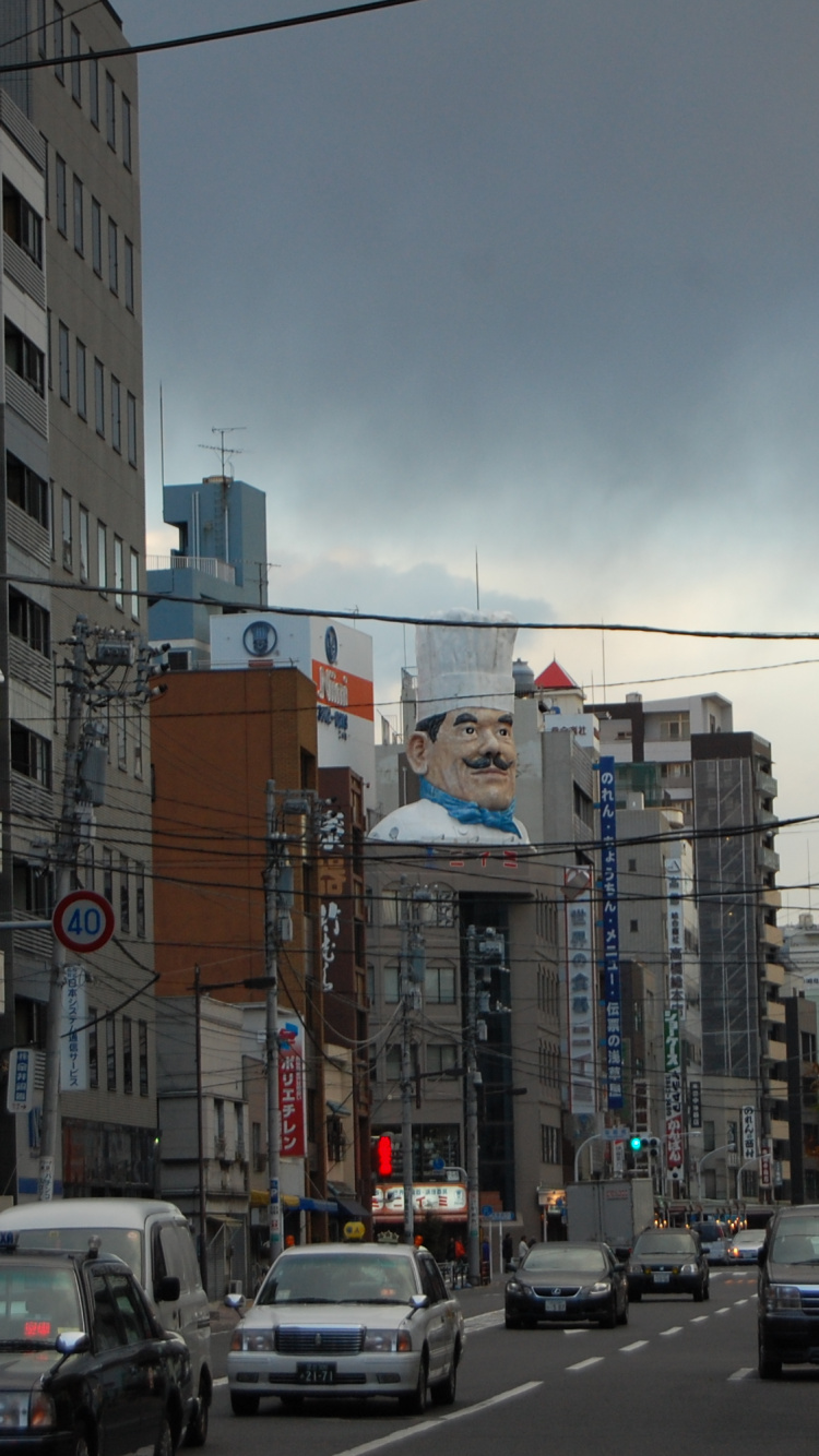 Cars on Road Between High Rise Buildings During Daytime. Wallpaper in 750x1334 Resolution