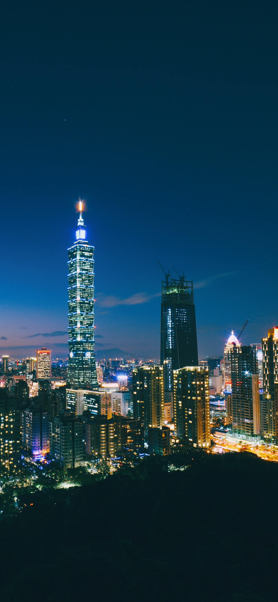City Skyline During Night Time. Wallpaper in 1125x2436 Resolution