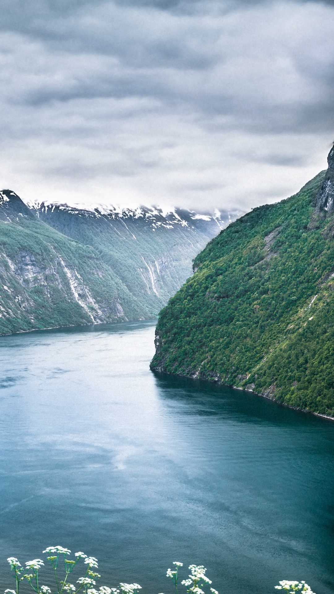 Green Lake Between Green Mountains Under Gray Clouds. Wallpaper in 1080x1920 Resolution