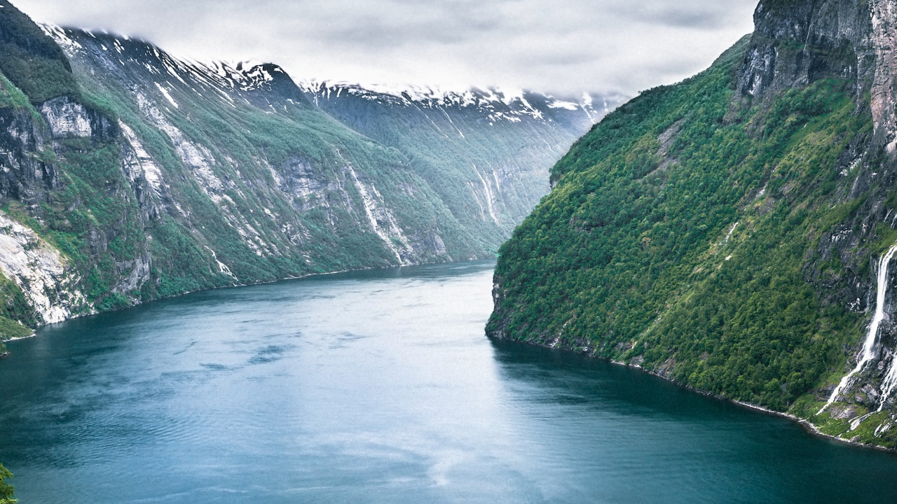Green Lake Between Green Mountains Under Gray Clouds. Wallpaper in 1280x720 Resolution
