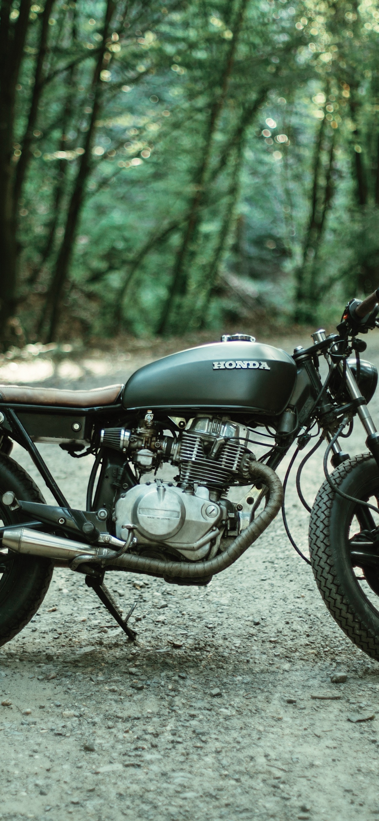 Motocicleta Negra Estacionada en Camino de Tierra Gris Durante el Día. Wallpaper in 1242x2688 Resolution