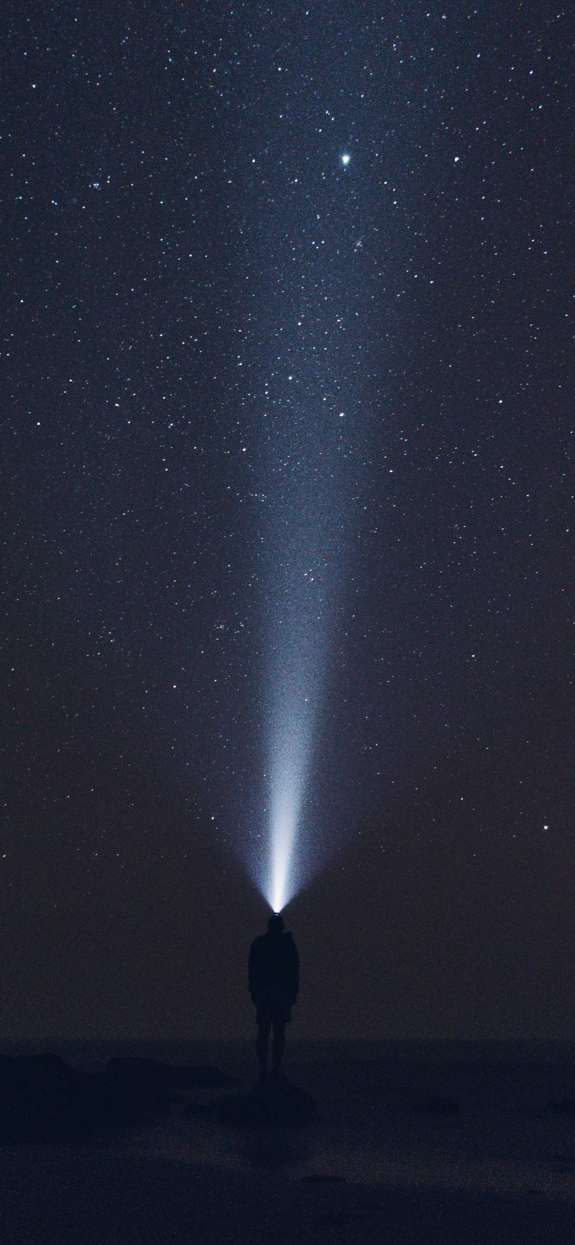 Hombre Con Chaqueta Negra de Pie Bajo la Noche Estrellada. Wallpaper in 1125x2436 Resolution