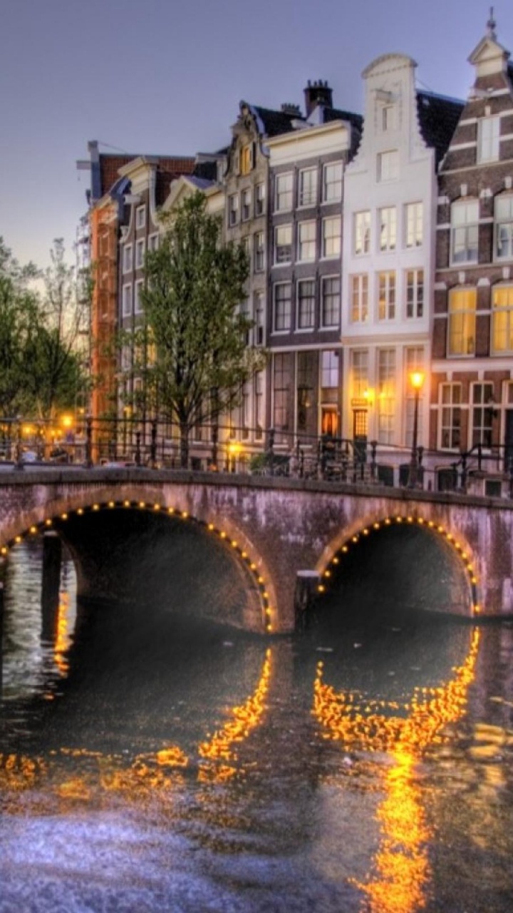 Edificio de Hormigón Marrón Cerca Del Río Durante el Día. Wallpaper in 720x1280 Resolution