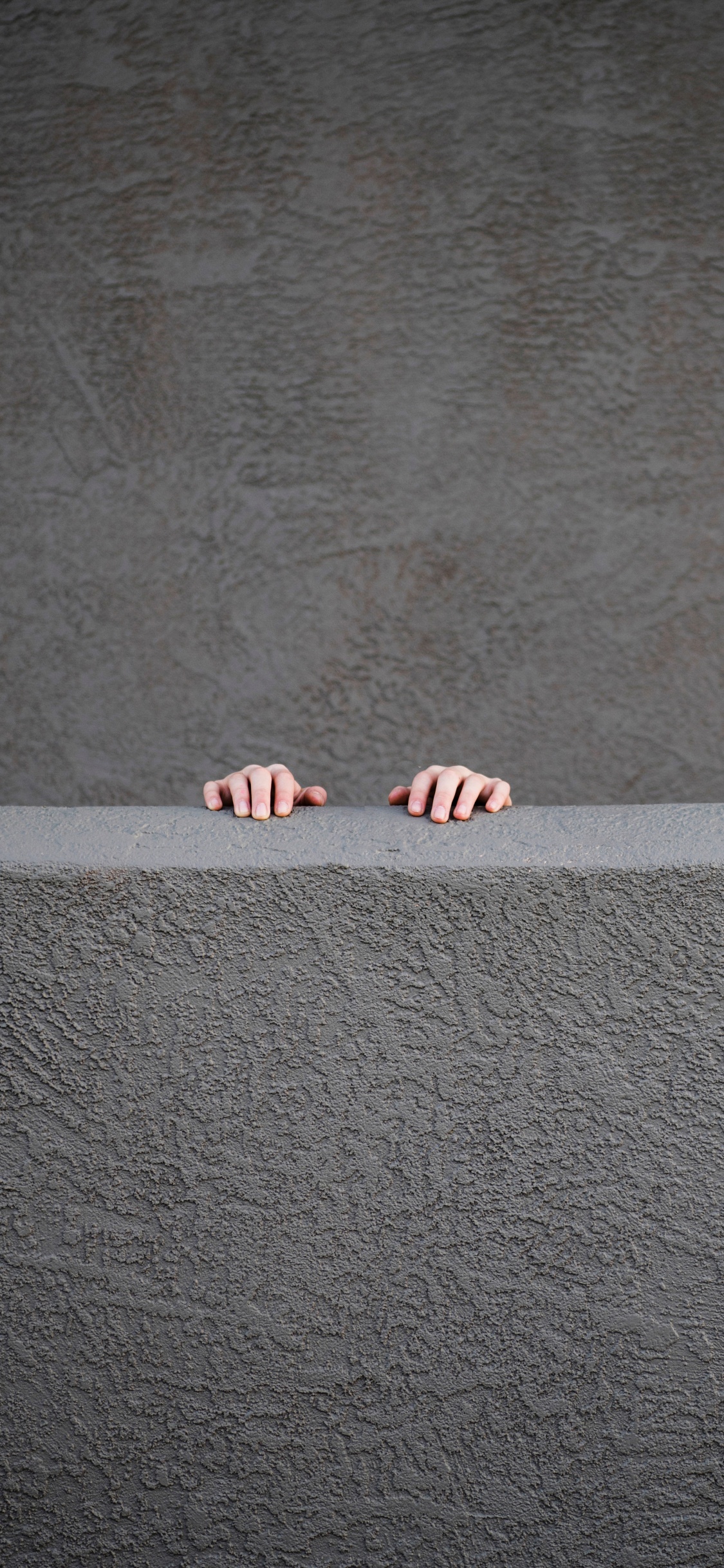 Person Standing on Gray Concrete Floor. Wallpaper in 1125x2436 Resolution