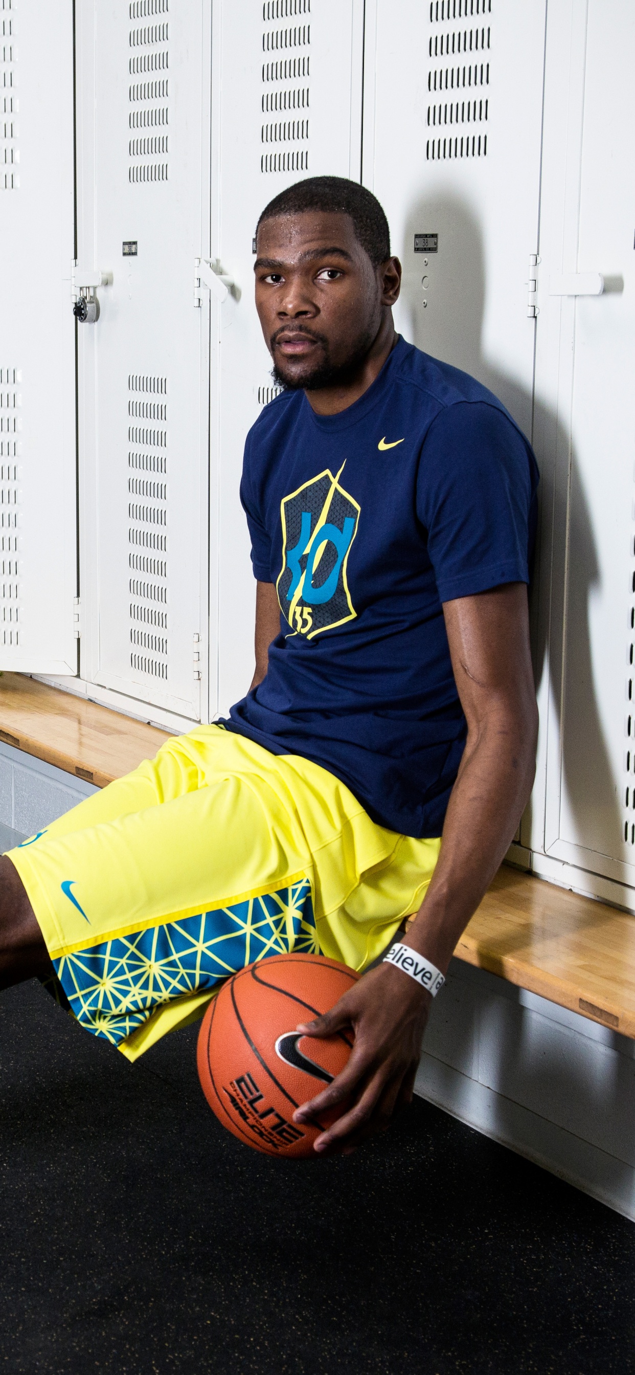 Homme en Maillot de Football Nike Bleu et Jaune Tenant le Basket-ball. Wallpaper in 1242x2688 Resolution