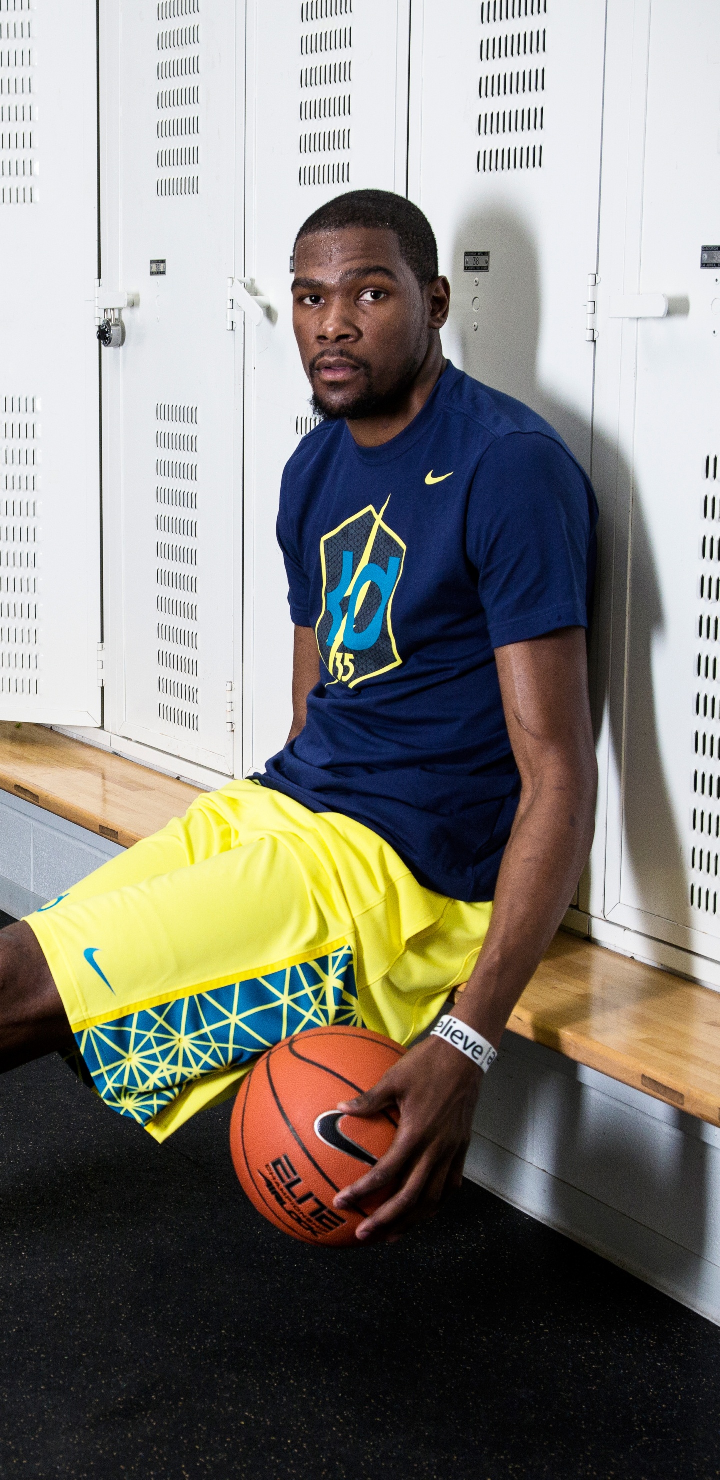 Homme en Maillot de Football Nike Bleu et Jaune Tenant le Basket-ball. Wallpaper in 1440x2960 Resolution