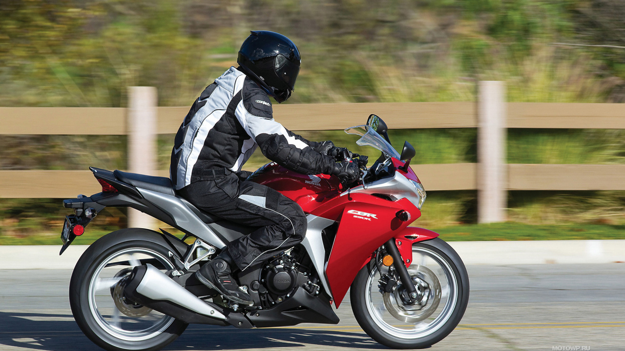 Man in Black and White Jacket Riding Red and Black Sports Bike. Wallpaper in 1280x720 Resolution