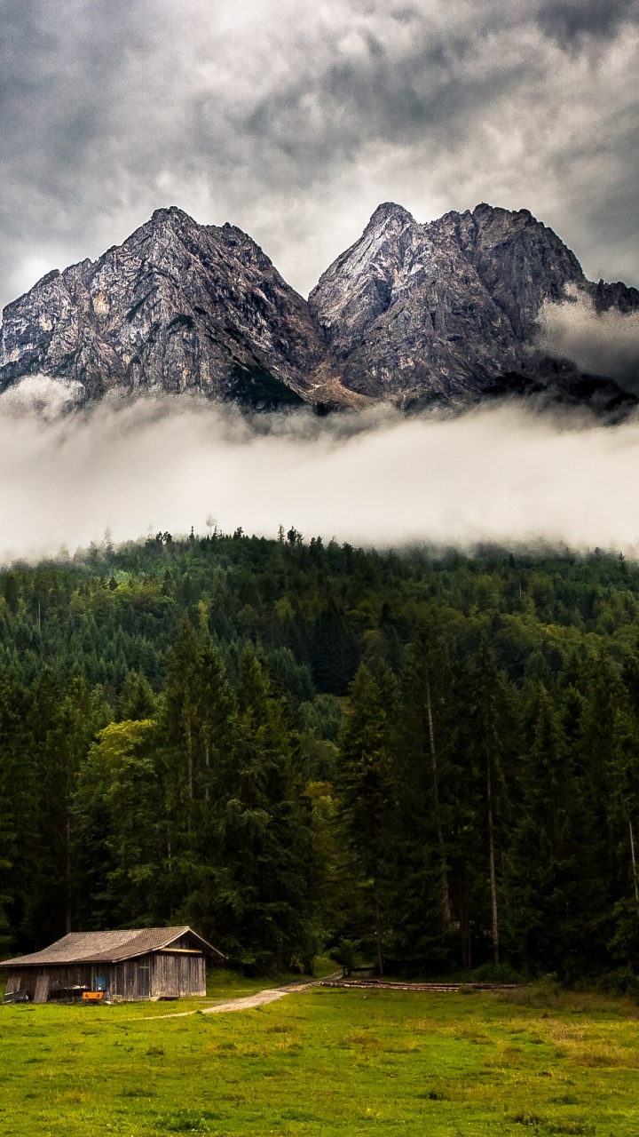 Brown Wooden House on Green Grass Field Near Green Trees and Mountain Under White Clouds During. Wallpaper in 720x1280 Resolution