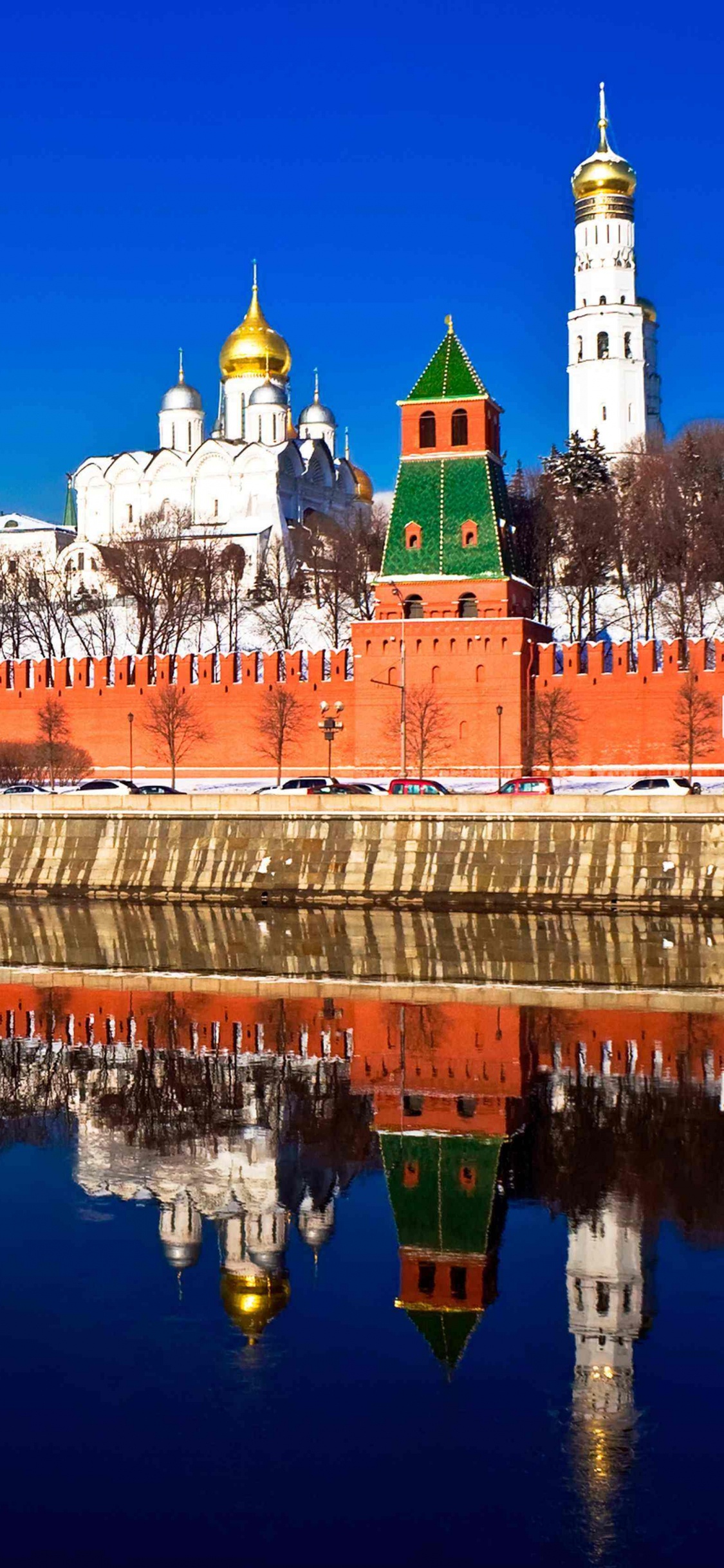 Edificio de Hormigón Marrón y Blanco Cerca Del Cuerpo de Agua Durante la Noche. Wallpaper in 1125x2436 Resolution