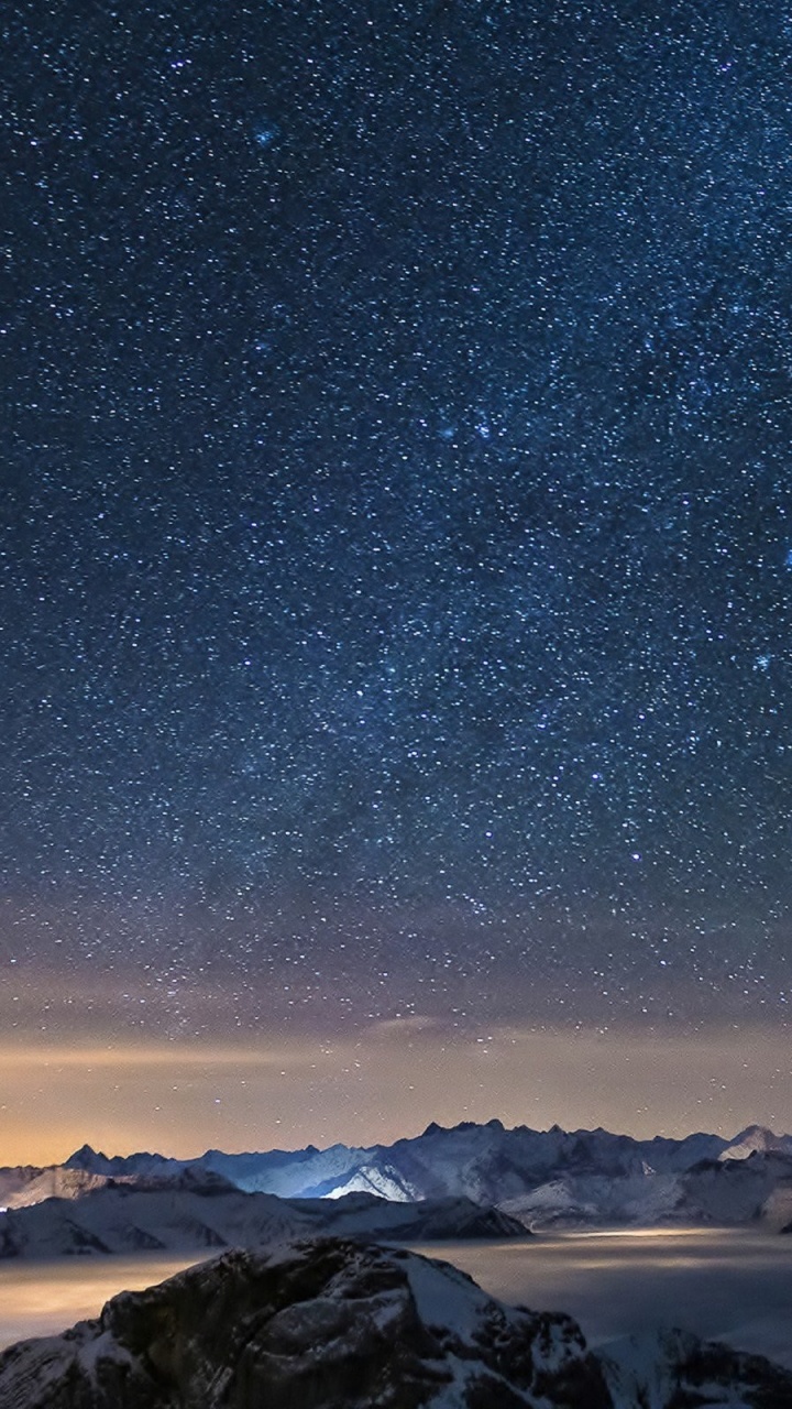 Snow Covered Mountain Under Starry Night. Wallpaper in 720x1280 Resolution