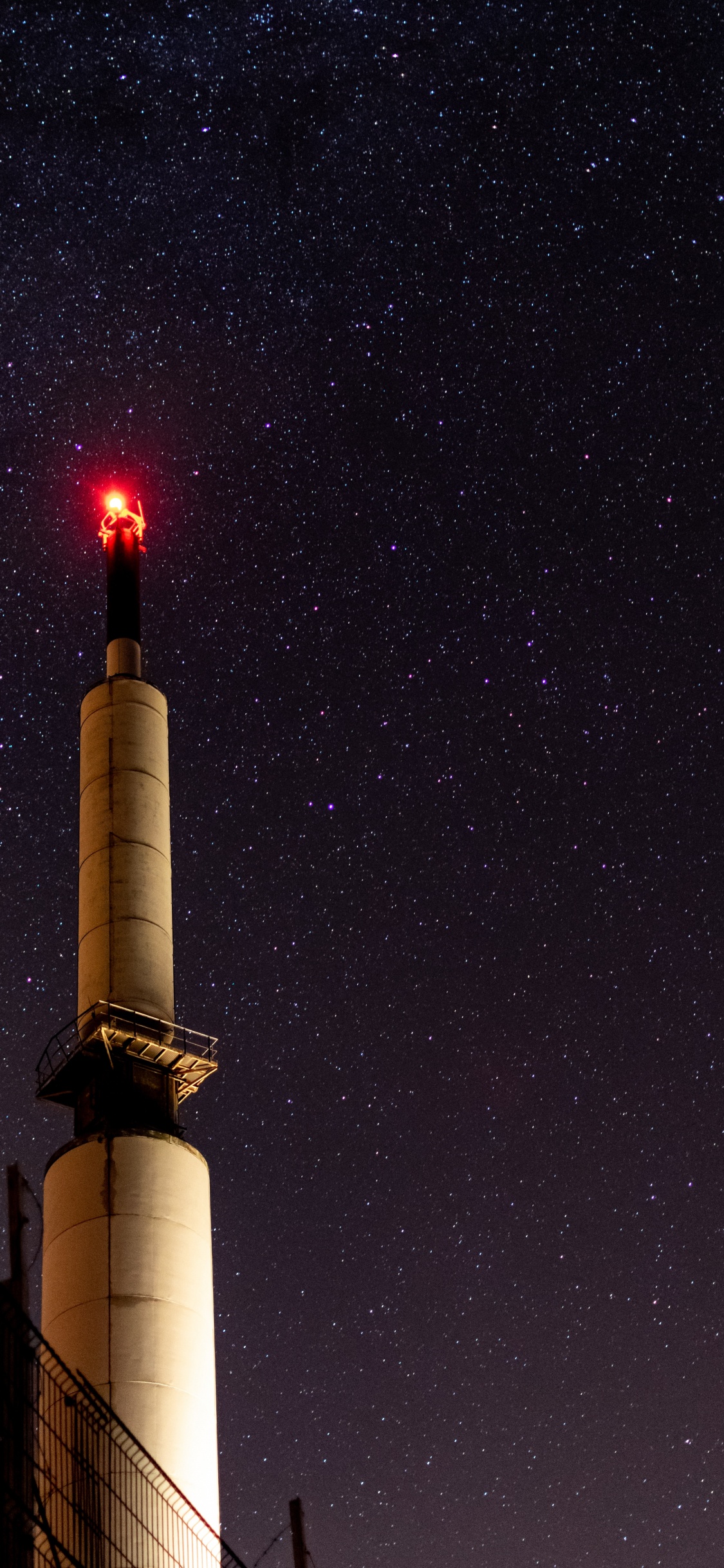 White and Brown Tower Under Starry Night. Wallpaper in 1125x2436 Resolution