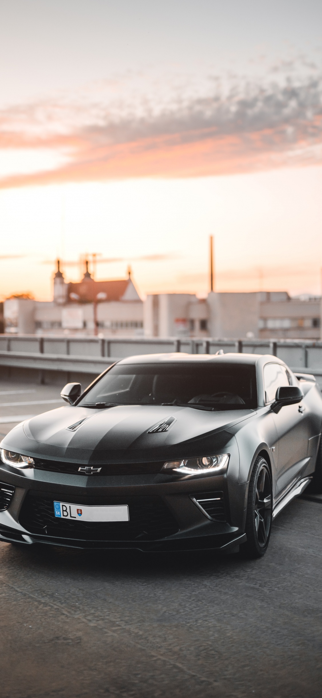 Porsche 911 Noire Sur Route Pendant le Coucher du Soleil. Wallpaper in 1125x2436 Resolution