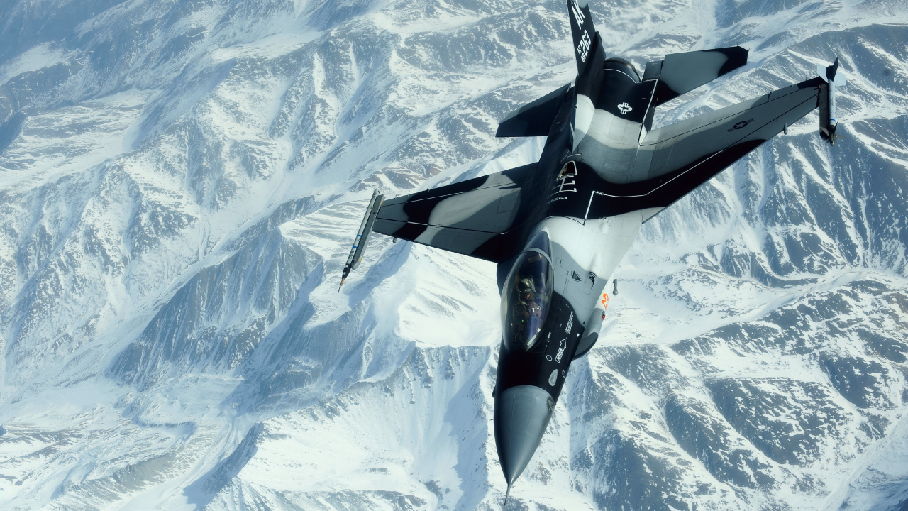 Schwarz-Weiß-Düsenflugzeug Fliegt Tagsüber Über Schneebedeckte Berge. Wallpaper in 1280x720 Resolution