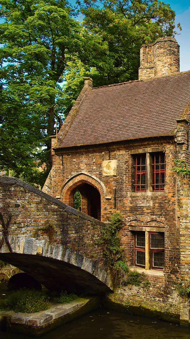 Brown Brick Building Near Green Trees During Daytime. Wallpaper in 750x1334 Resolution