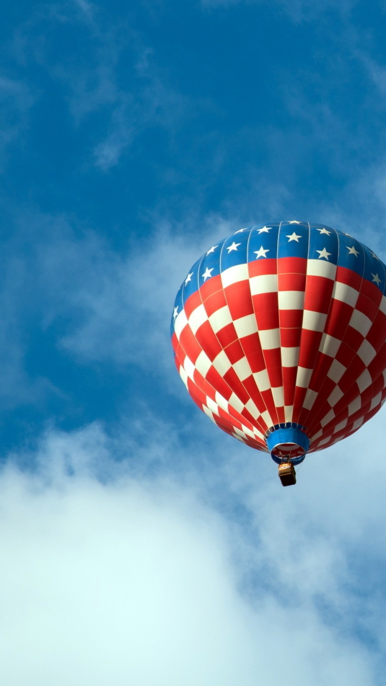 Red Blue and Yellow Hot Air Balloon in Mid Air Under White Clouds and Blue Sky. Wallpaper in 750x1334 Resolution