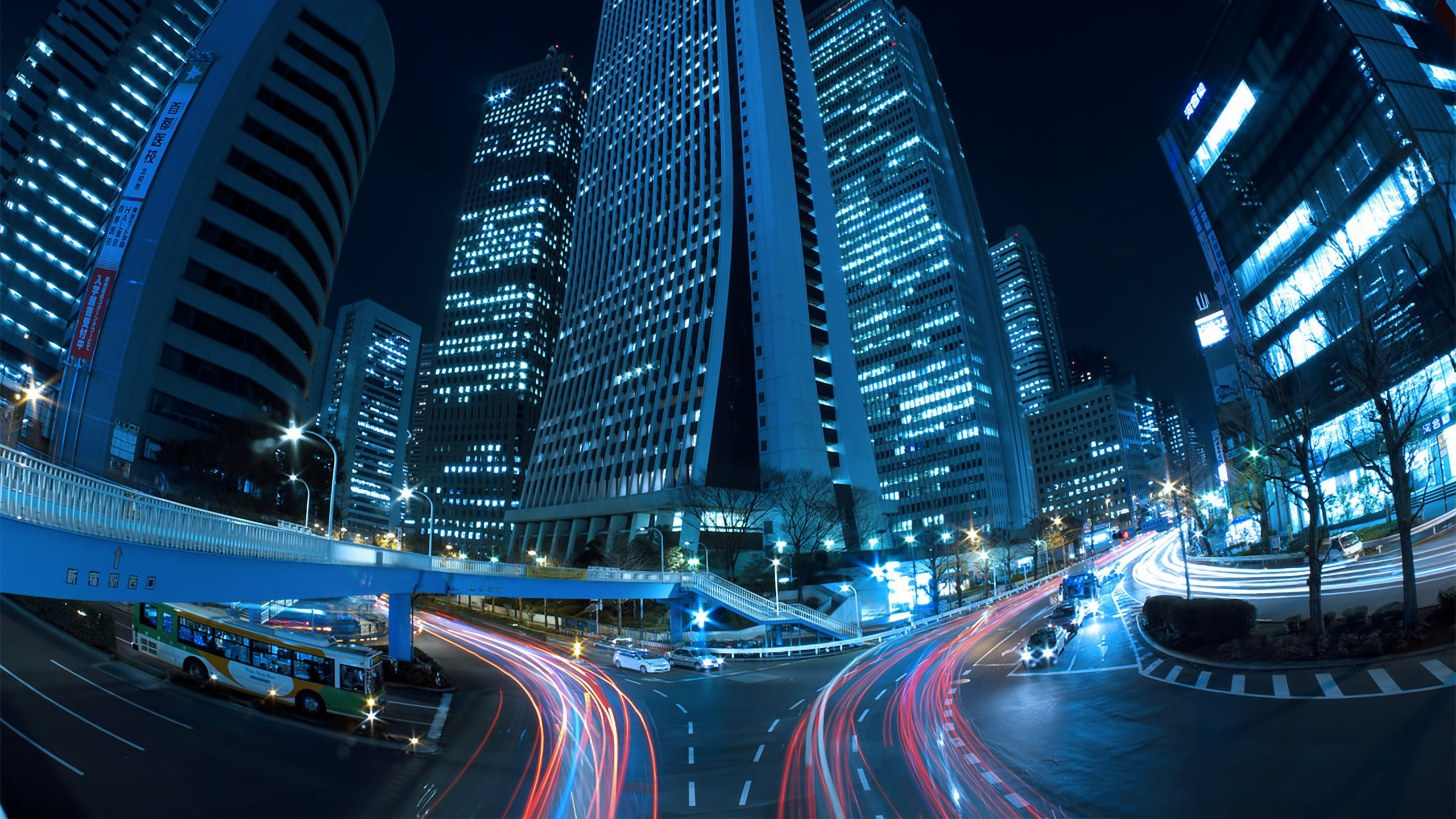 Cars on Road Near High Rise Buildings During Night Time. Wallpaper in 2560x1440 Resolution