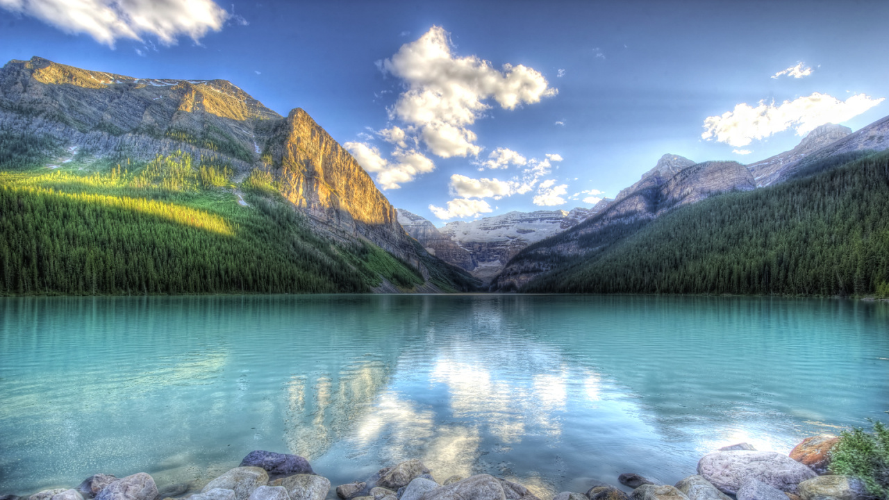 Green and Brown Mountains Beside Lake Under Blue Sky During Daytime. Wallpaper in 1280x720 Resolution