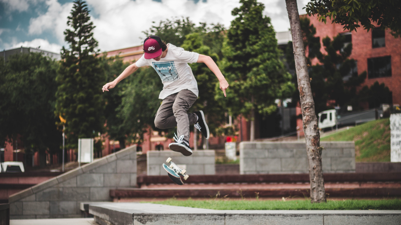 Man in Blue Shirt and Gray Pants Jumping on Brown Concrete Brick During Daytime. Wallpaper in 1280x720 Resolution