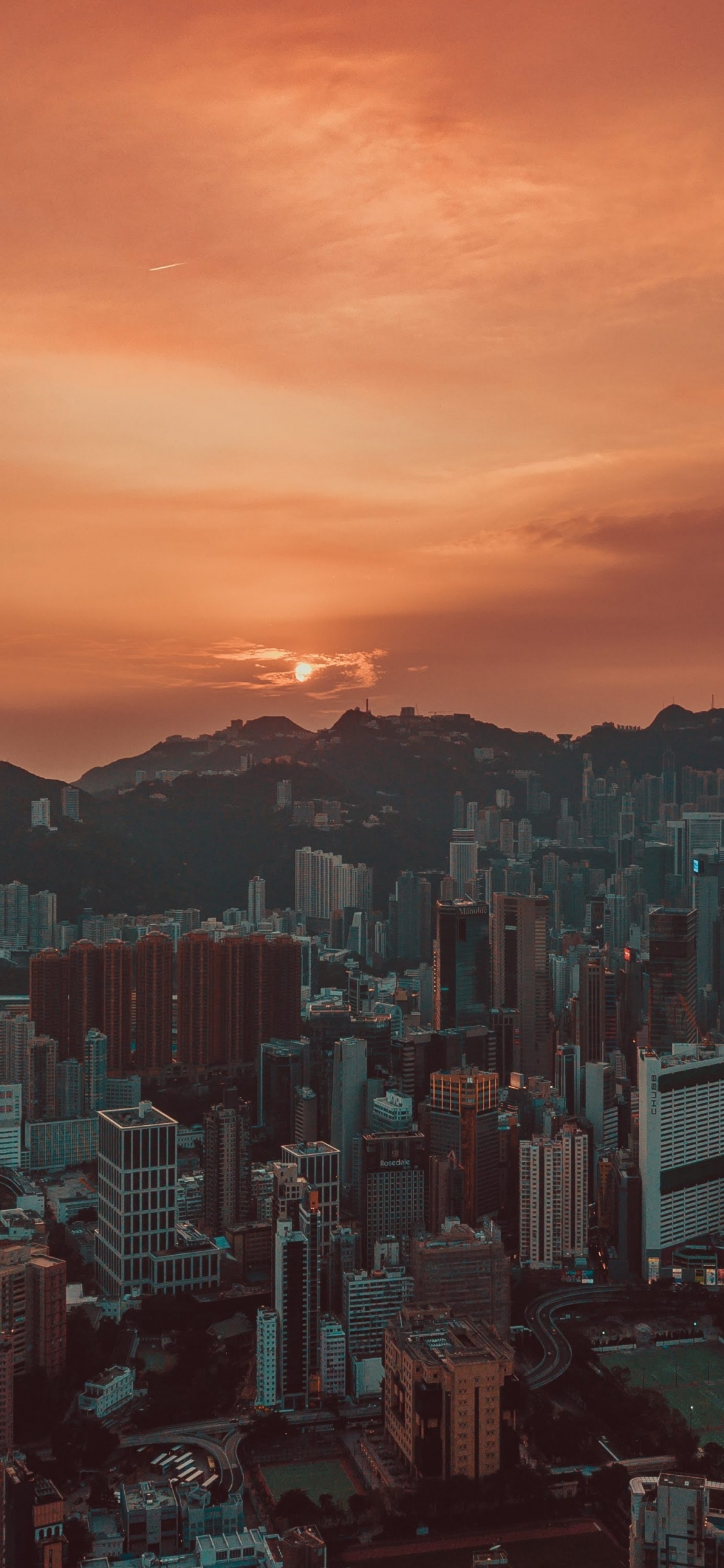 Skyline Der Stadt Während Des Orangefarbenen Sonnenuntergangs. Wallpaper in 1125x2436 Resolution
