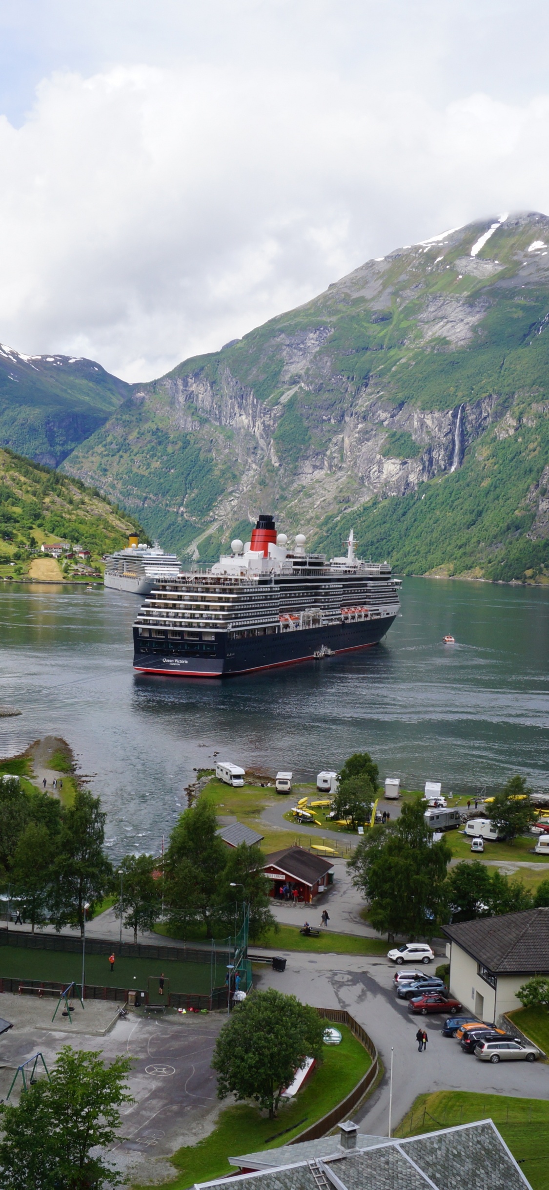 Red and White Boat on River Near Green Mountains Under White Clouds During Daytime. Wallpaper in 1125x2436 Resolution