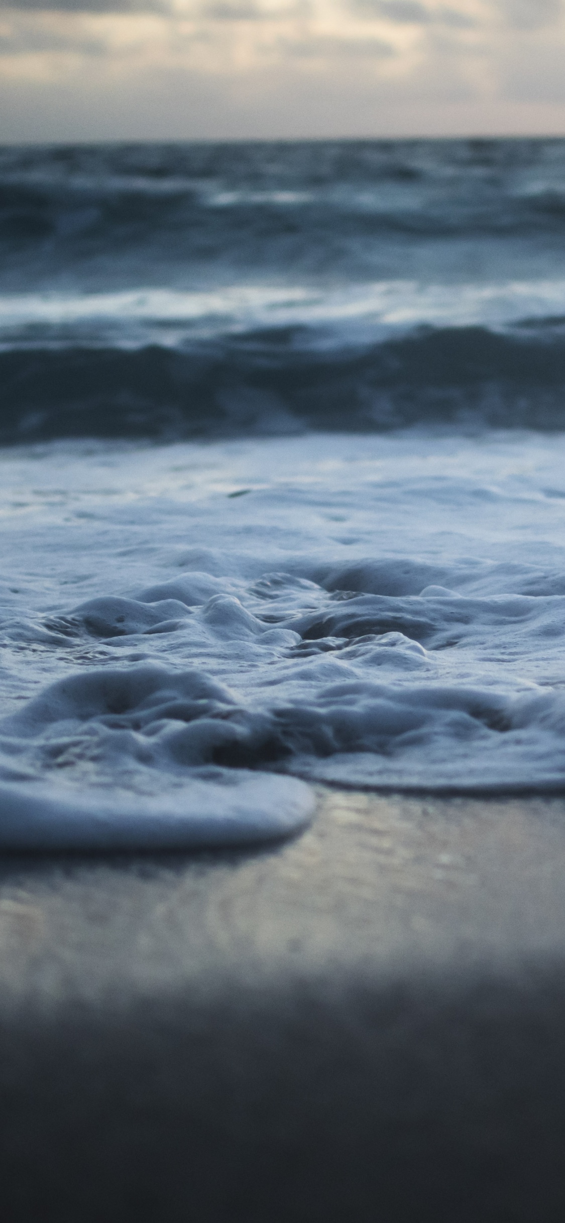 Sea Waves Crashing on Shore During Sunset. Wallpaper in 1125x2436 Resolution