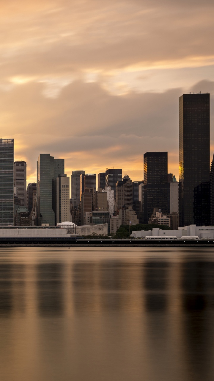 City Skyline Across Body of Water During Sunset. Wallpaper in 720x1280 Resolution