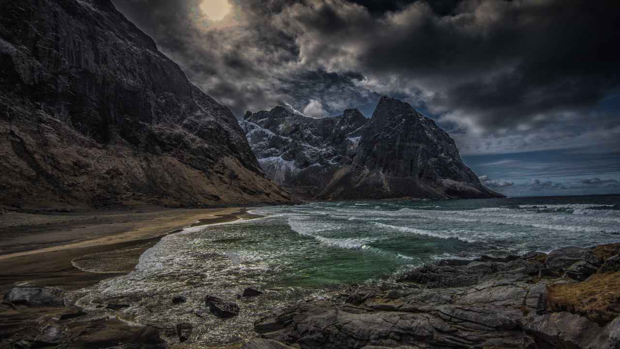 Brown Rocky Mountain Beside Body of Water Under Cloudy Sky During Daytime. Wallpaper in 1280x720 Resolution