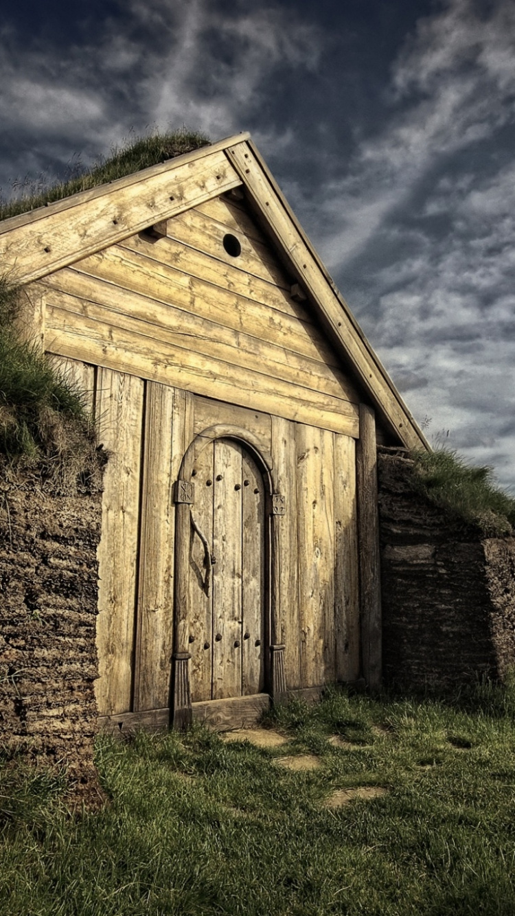 Braunes Holzhaus Auf Grüner Wiese Unter Blauem Himmel Tagsüber. Wallpaper in 750x1334 Resolution