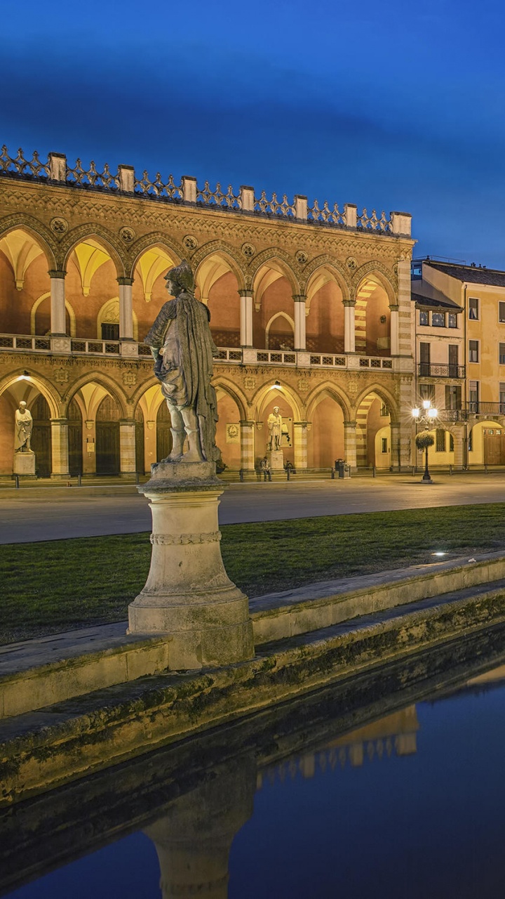 Braunes Betongebäude in Der Nähe Von Gewässern Während Der Nacht. Wallpaper in 720x1280 Resolution