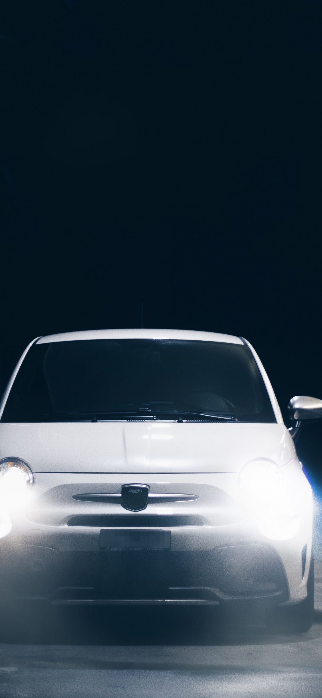 White Car in a Dark Room. Wallpaper in 1125x2436 Resolution