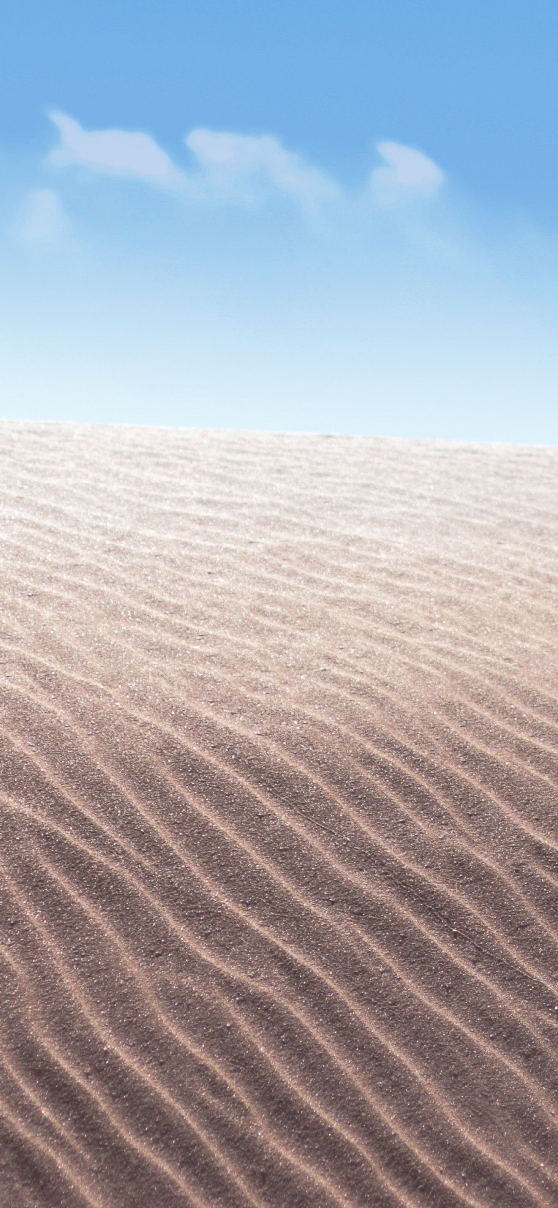 Brown Sand Under Blue Sky During Daytime. Wallpaper in 1125x2436 Resolution