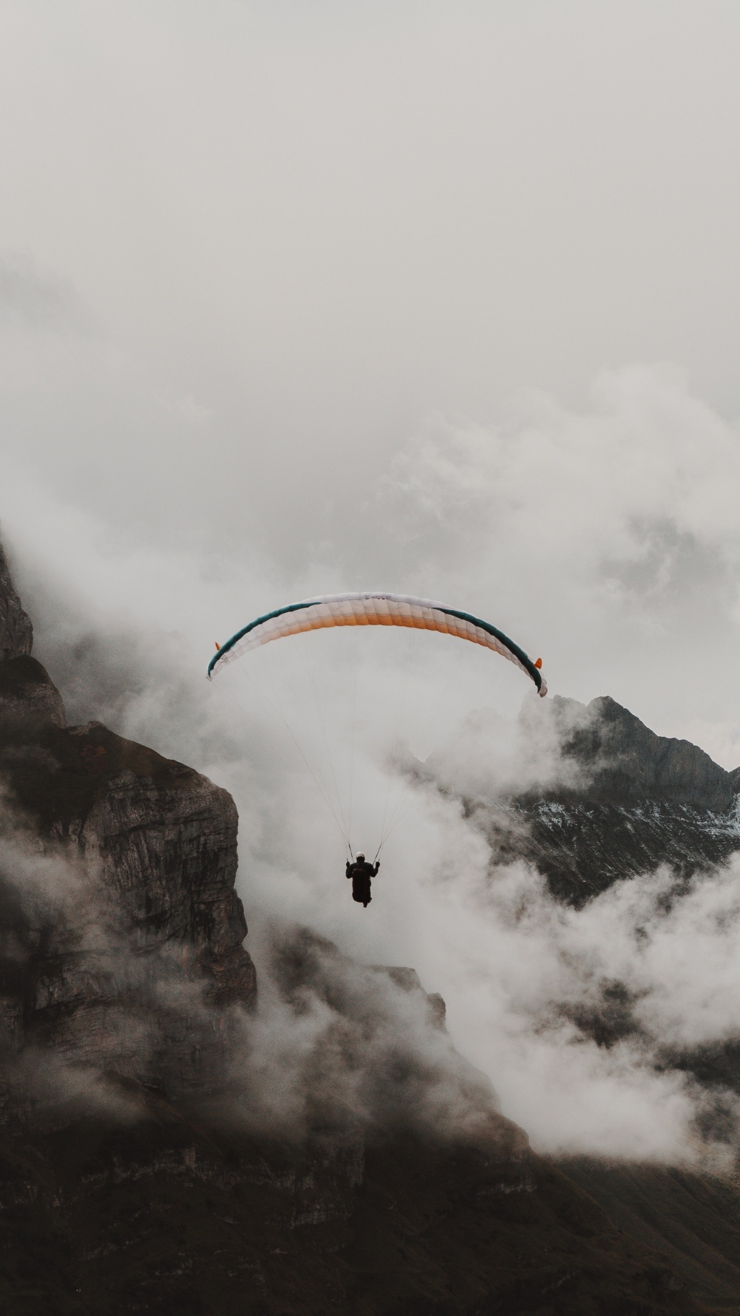 Person Reitet Fallschirm Über Schneebedeckten Berg. Wallpaper in 1080x1920 Resolution